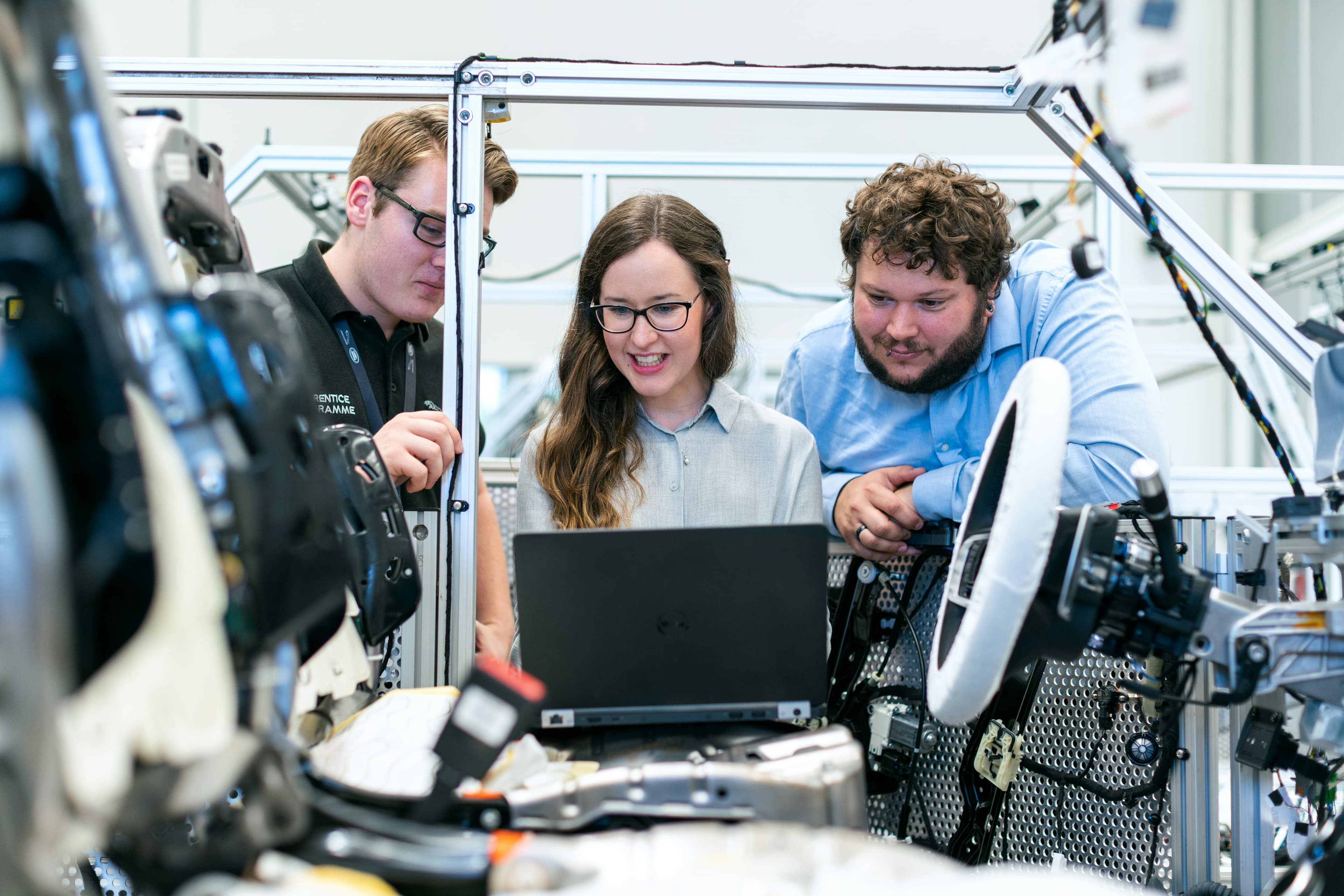 BeeMotors engineers reviewing live vehicle telemetry on a laptop in the workshop